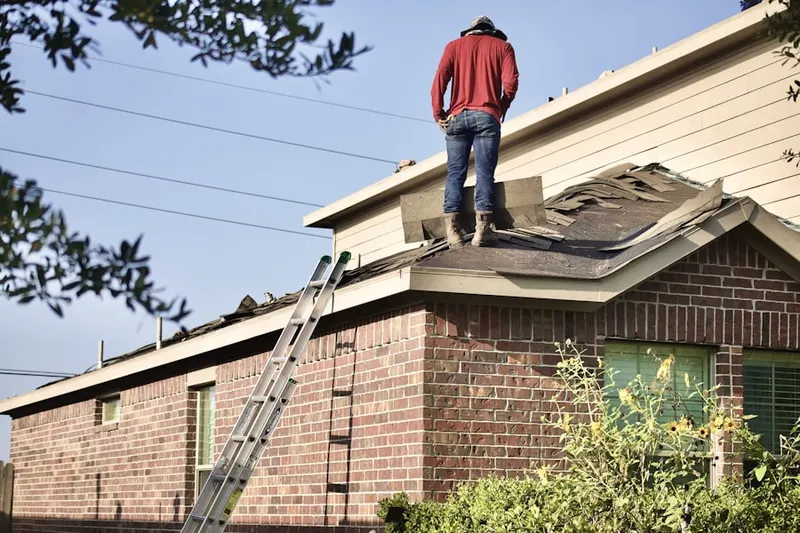 Professional roofer working on a residential roof in Whipple